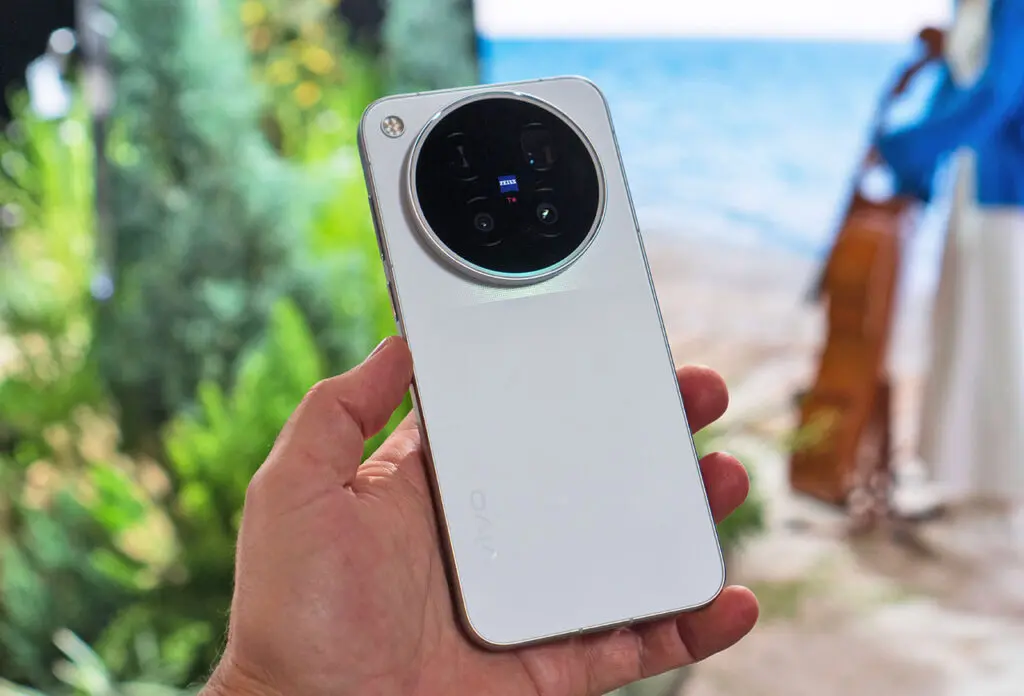 Mặt lưng màu trắng bạc của điện thoại Vivo X500 với cụm camera tròn lớn Zeiss trên tay người dùng